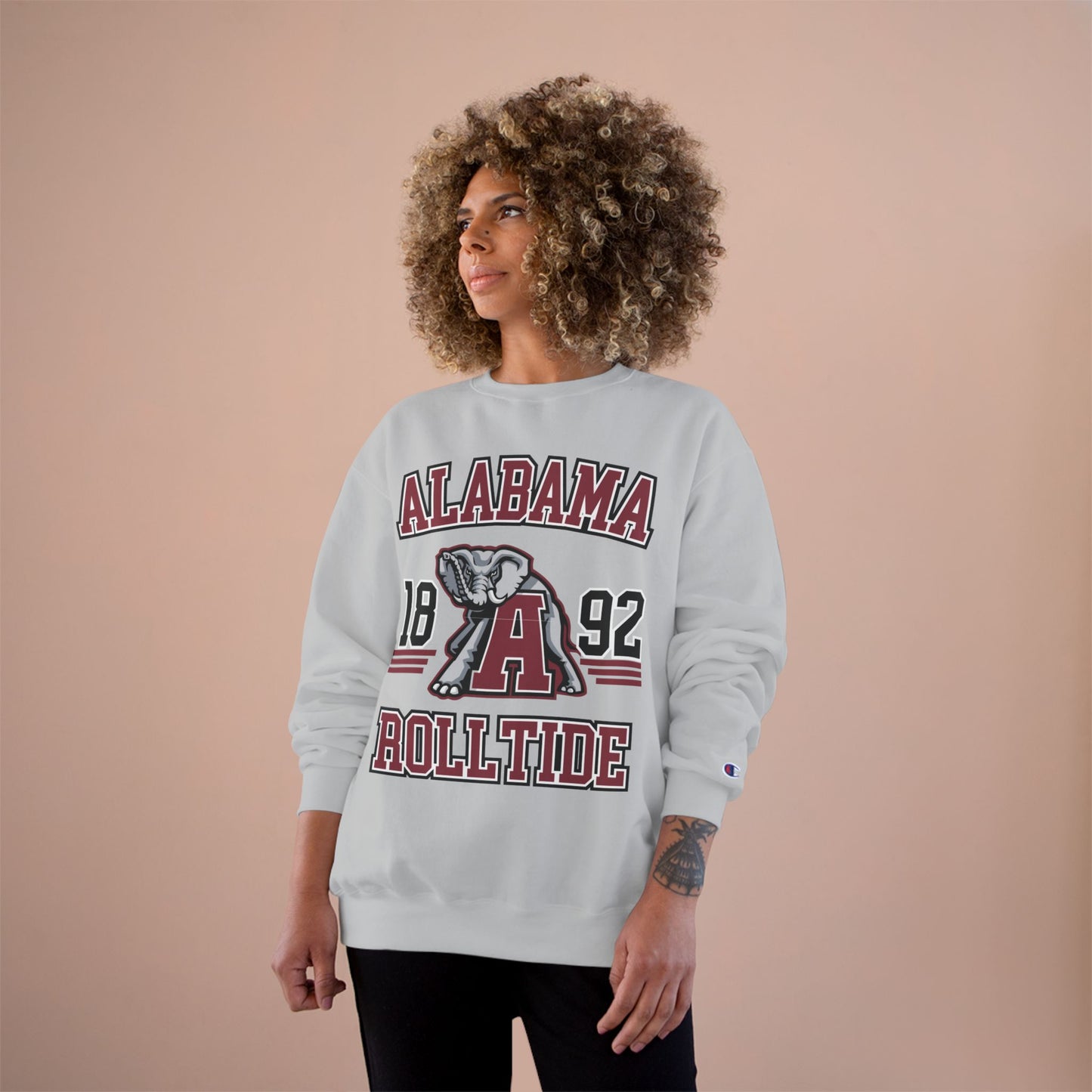 Person wearing an Alabama Roll Tide sweatshirt on a beige background