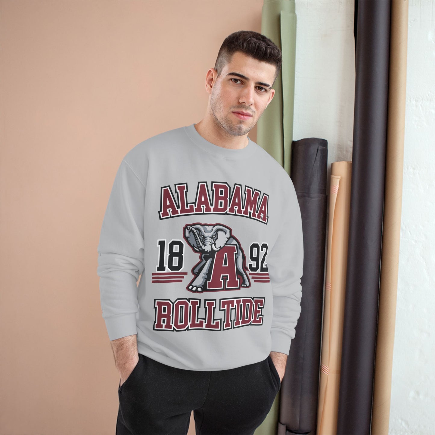 Man wearing a gray sweatshirt with 'Alabama Roll Tide' design in a room.