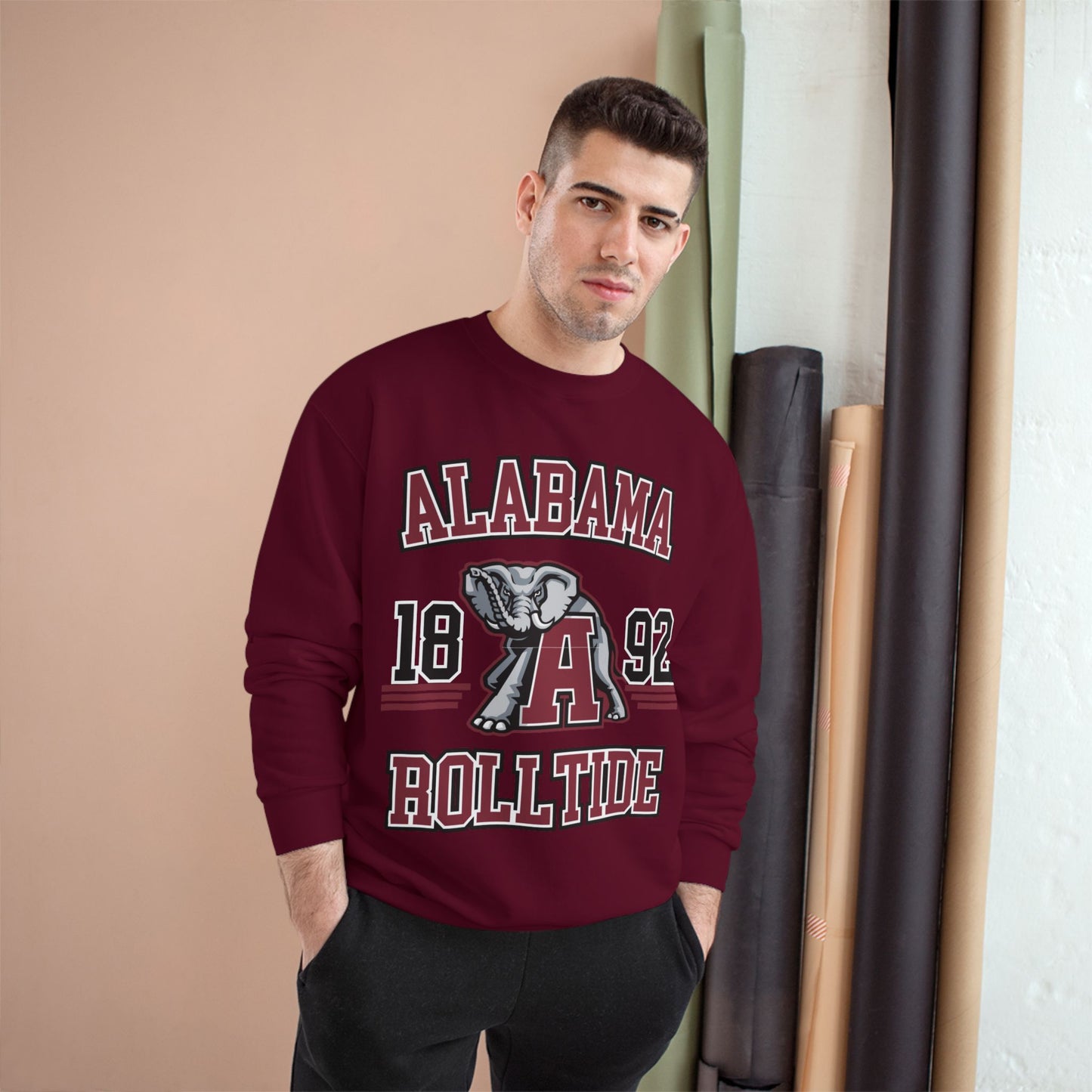 Man wearing a maroon 'Alabama Roll Tide' sweatshirt in an indoor setting.