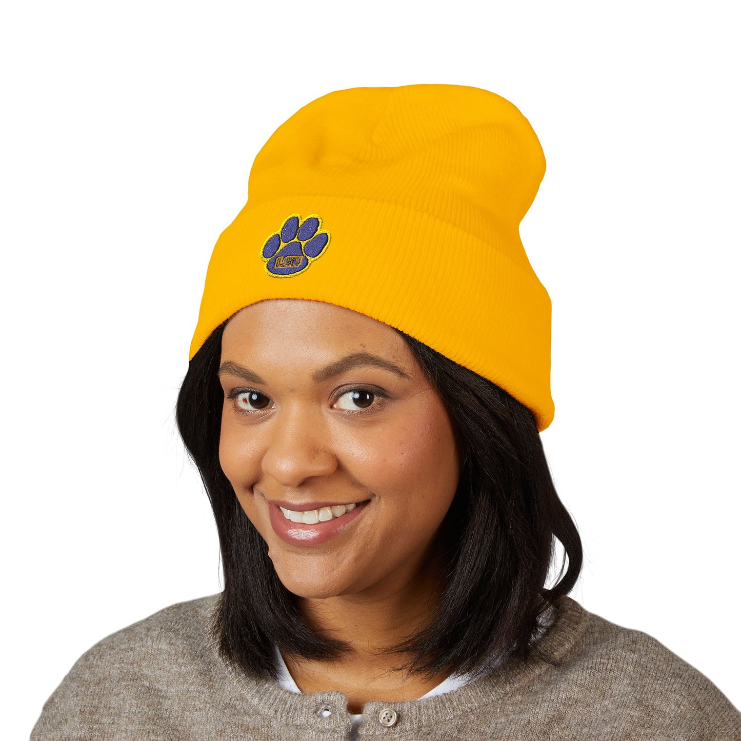 Person wearing a yellow beanie with a paw print logo on a white background