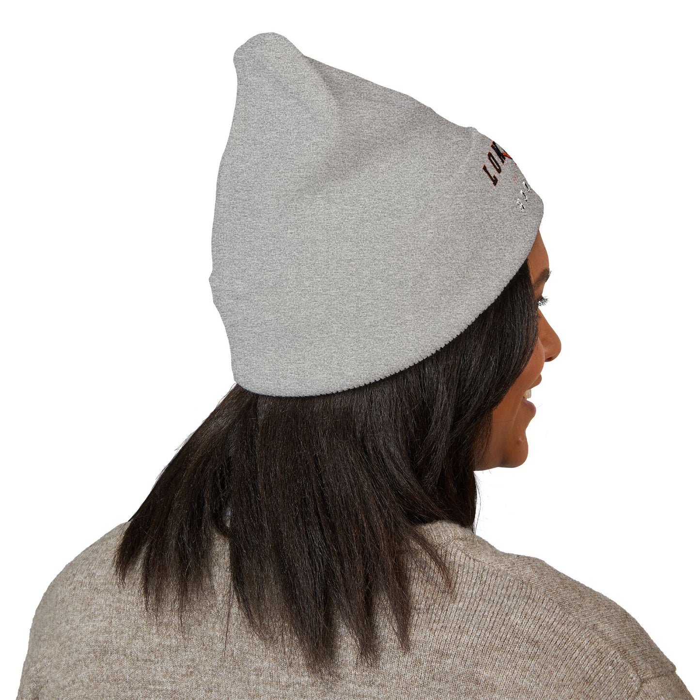 Person wearing a gray beanie with a brand logo on a white background with texas longs horns hook em logo