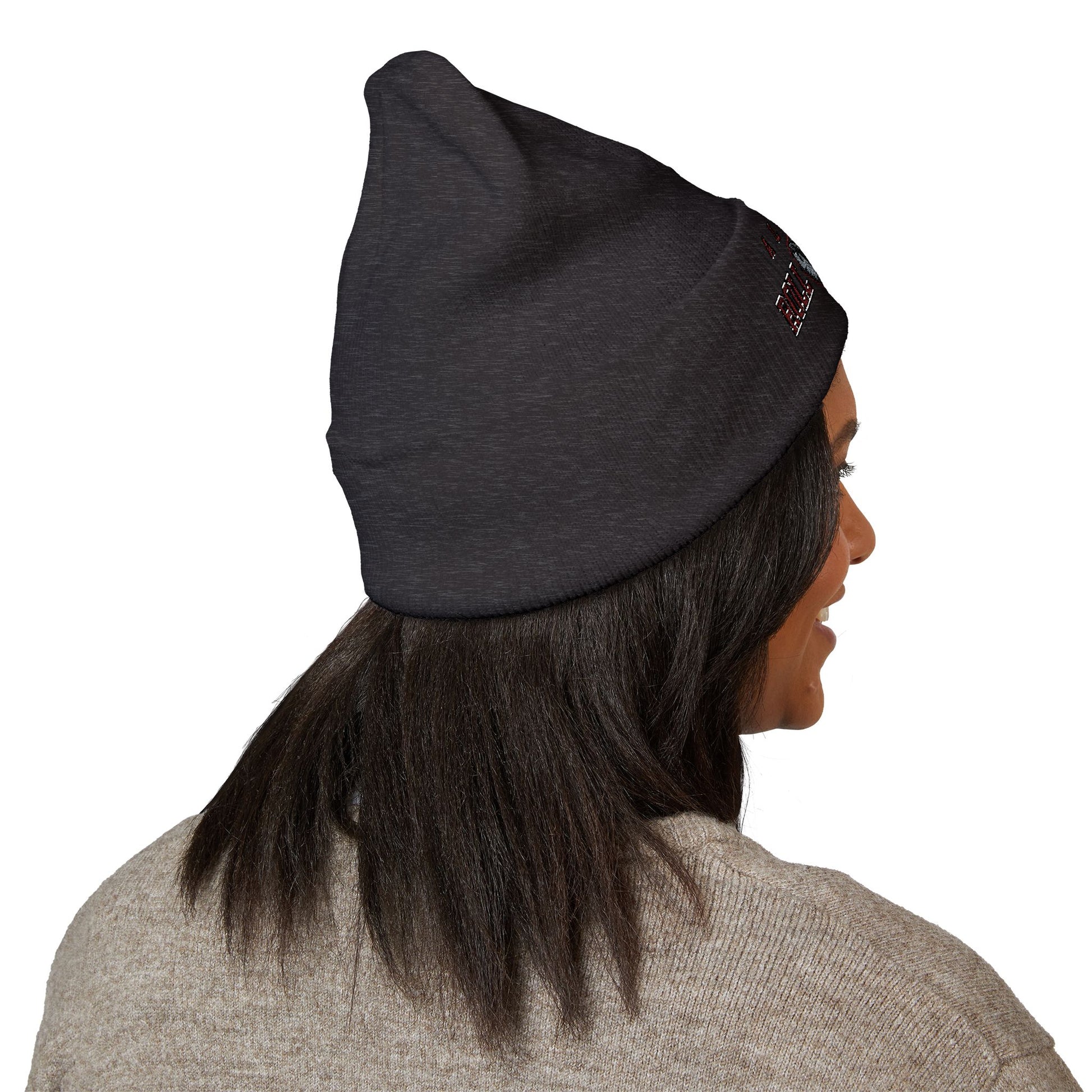 Person wearing a dark gray beanie with a alabama roll tide brand logo on a white background